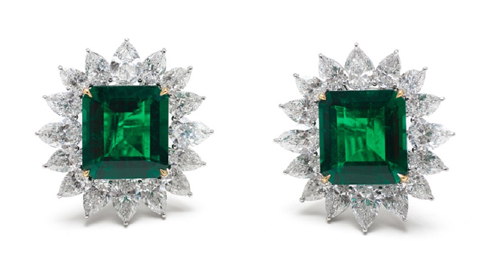 AN IMPECCABLE PAIR OF EMERALD CUT COLOMBIAN EMERALDS, EACH SET IN EARRINGS WITHIN A PEAR-SHAPED DIAMOND SURROUND.